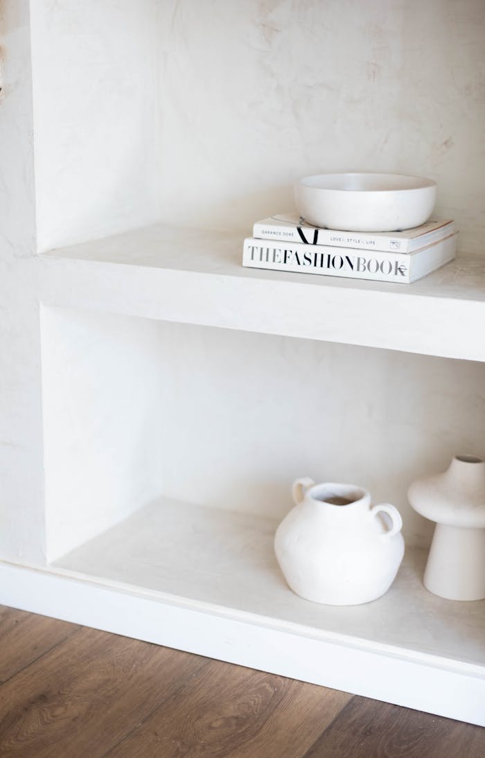 A minimalist interior shelf featuring ceramic vases and books, perfect for modern homes.
